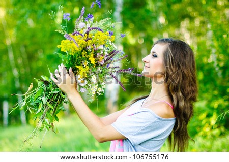 Portrait of smiling young woman  at the green forest with flowers