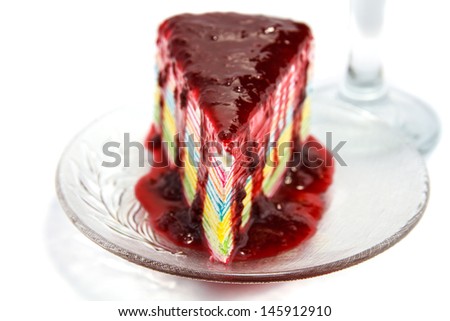 Fancy cake topped with a berry on white background.