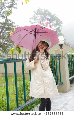 Happy girl an umbrella in the rain.