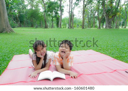 Asia boy and girl reading book in the garden.
