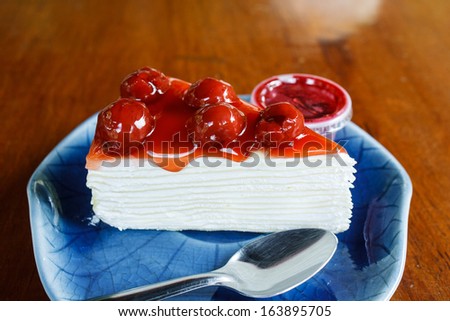 Crepe cake topped with cherries and jam for topping.
