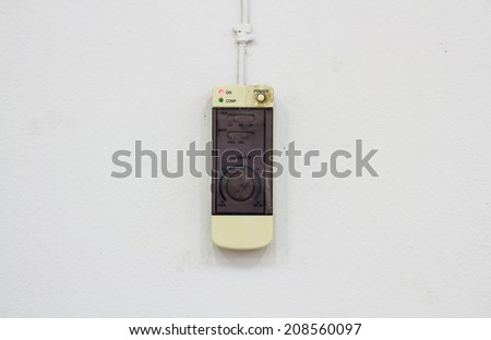 Remote air conditioner control on white wall.