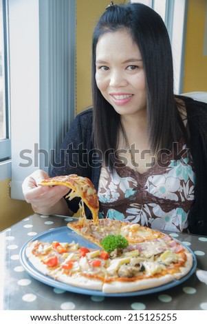 Asian woman eat pizza in a restaurant
