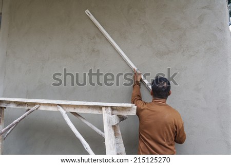 Workers were plastering on wall in house.