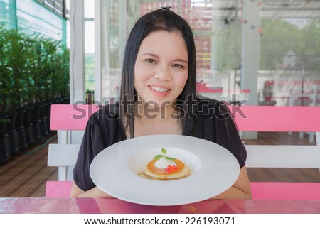 Girl eat Custard caramel in the restaurant
