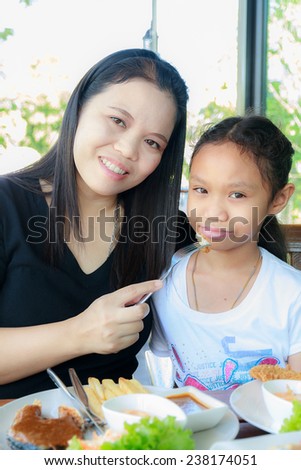 Asia mother and daughter happy in restaurant.
