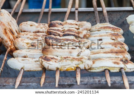 Grilled banana skewers on stove in market. Thailand dessert.