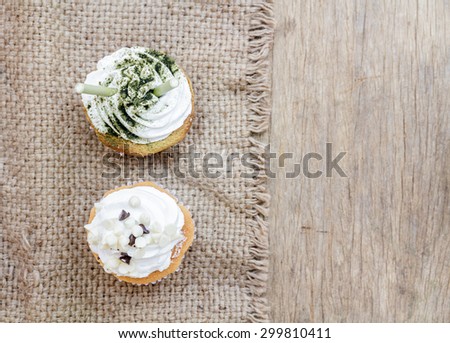 Cupcake matcha green tea and chocolate put on a hemp cloth on the wood. top view.