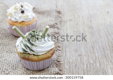 Cupcake matcha green tea and chocolate put on a hemp cloth on the wood.