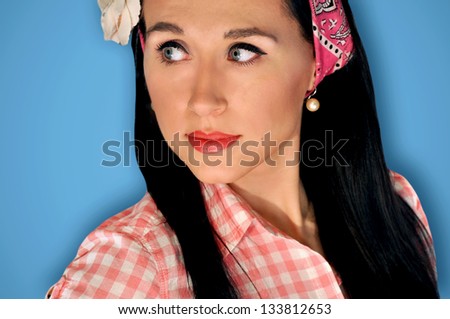 Vintage, retro portrait of a beautiful, brunette pin up girl on blue background.