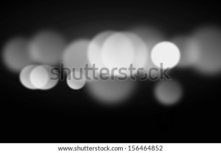 Beautiful black and white blurred lights on a dark background