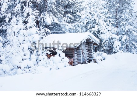 Small wooden blockhouse in the twilight, in winter under the snow in the snowy forest of pine trees, winter landscape
