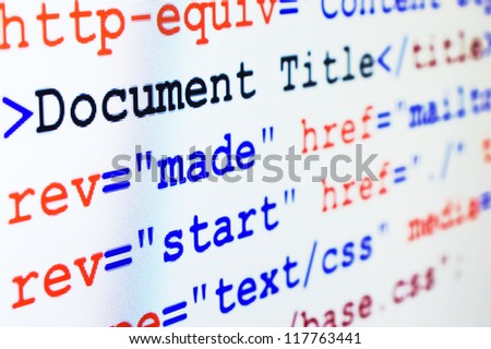 HTML source code of web page with document title, metadata description and links monitor screenshot diagonal view, small depth of sharpness