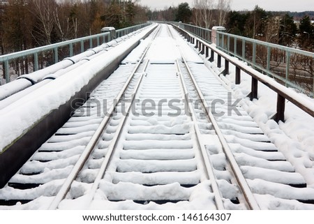 The railroad in the winter under the snow in cloudy weather, perspective view
