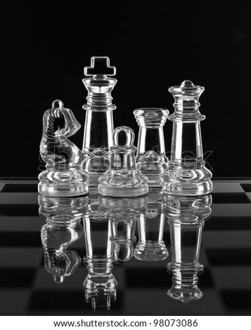 Glass chess family with reflection on black background