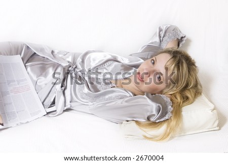 A women in a silver silk robe on the sofa