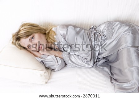 A tired women in a silver silk robe