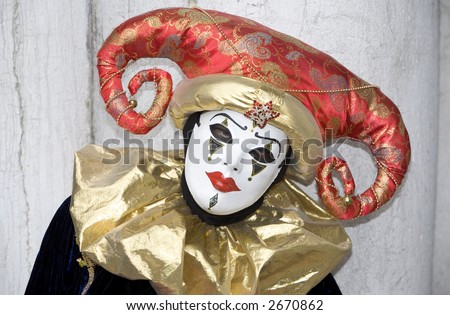 A sad clown with a red hat and gold collar
