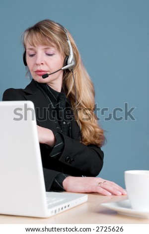 An annoyed customer service agent with a cup of coffee and a white computer