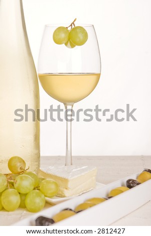 An abstract with white wine, grapes, cheese and olives