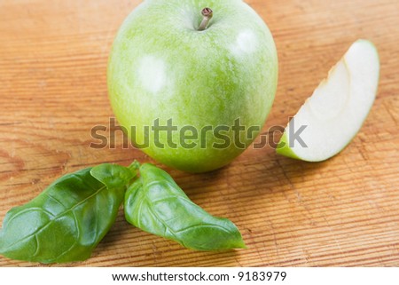 A green apple with a freshly cut apple slice