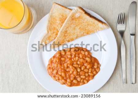 Delicious baked beans on toast with a glass of orange juice