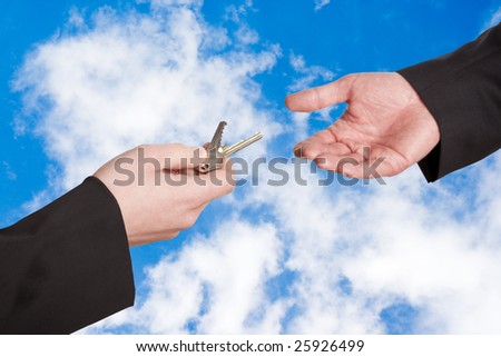 Concept of handing over the keys with a cloudy blue sky in the background