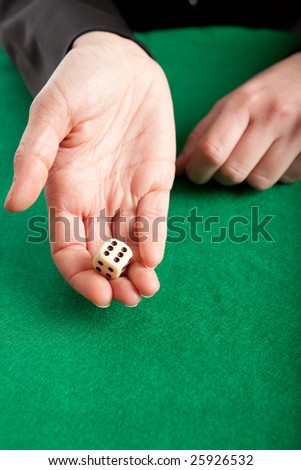 Gambler about to roll a white dice