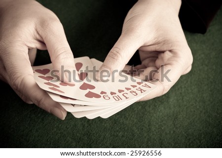 Gambler holding the perfect hand (Ace, King, Queen, Jack, Ten and Nine of hearts)