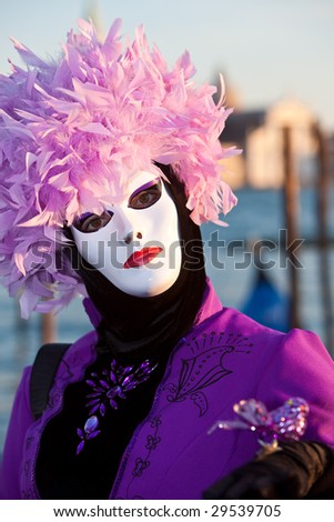 Purple and black costume with a white mask at the Venice Carnival