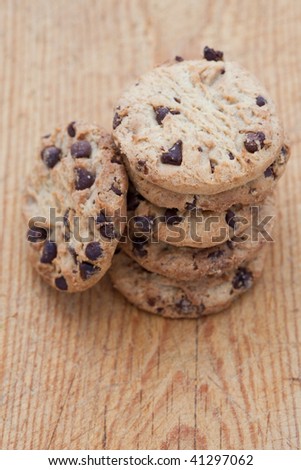 Freshly baked chocolate chip cookies on a wooden board