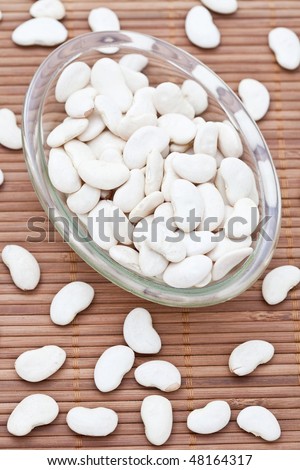 White butter beans in a dish on a bamboo mat