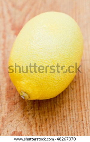 Single whole lemon on a wooden board