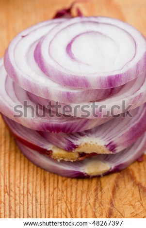 Slices of red onion on a wooden board