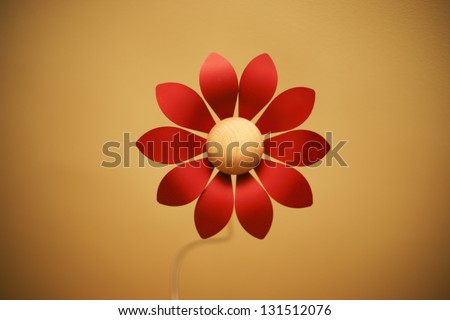 Plastic red flower isolated in orange background.