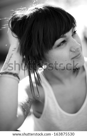 Portrait of beautiful young girl in urban background. Looking at infinity. Black and white image.