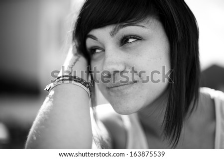 Portrait of beautiful young girl in urban background. Looking at infinity. Black and white image.