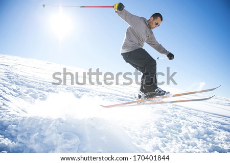 Freestyle ski jumper with crossed skis in snowy mountains