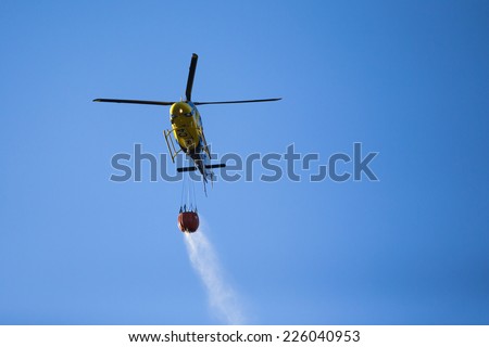 GRANADA, AUGUST 28: Fire fighting Helicopter, with bambi basket, during a fire fighting in the bush. August 28, 2014, Granada, Spain.