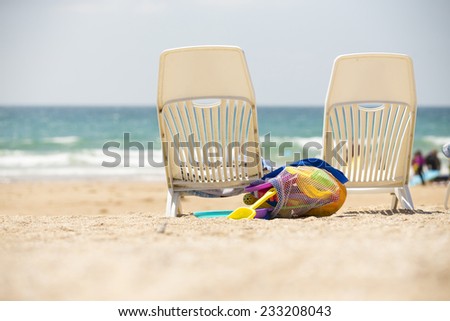 Beach, two deck chairs with toysand blue sky