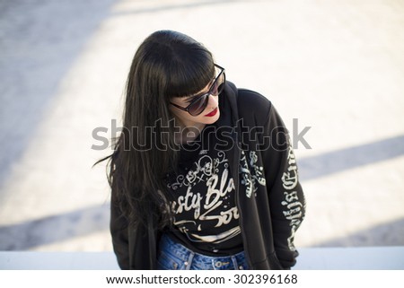 Portrait of a young beautiful woman in a urban background wearing black clothing