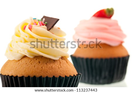 Vanilla cupcake with strawberry cupcake at the background over white