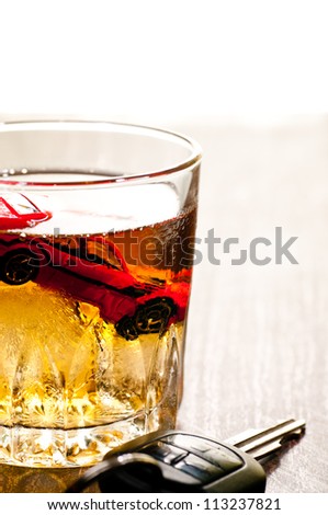 Toy car in a glass of whisky close up with a don\'t drink and drive concept