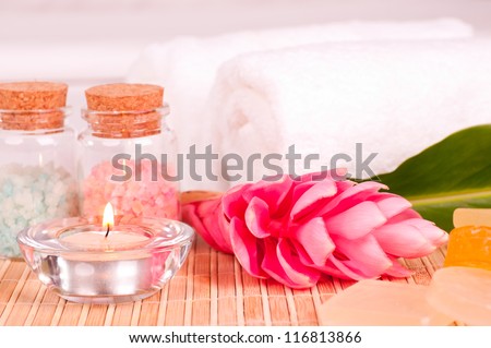 Spa background with bath salt and pink ginger flower close up