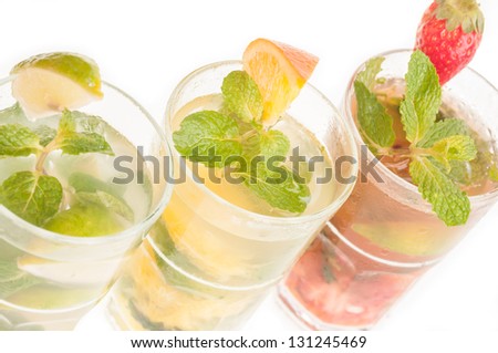 Three variation of Mojito top view close up,  a Cuban cocktail made with cuban rum, lime, sugar, a splash of soda and flavoured with fresh fruit of your choice