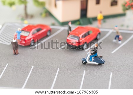 Busy street with miniature people, cars and scooter