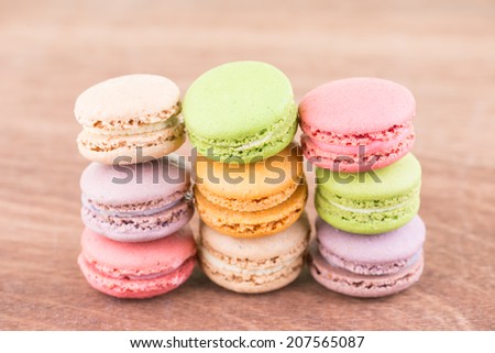 Colorful Macaroon stacked up on a wooden background close up