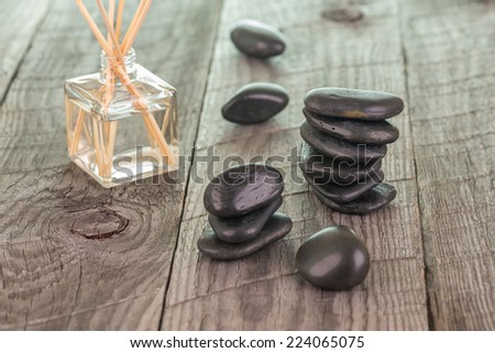 Aromatherapy sticks and black stones on weathered deck background
