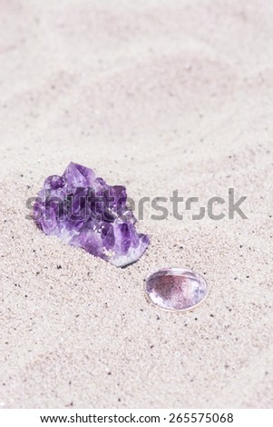 Natural rough Amethyst stone and brilliant cut Amethyst stone on sand background