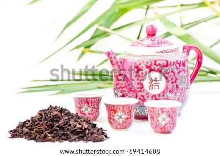 Chinese tea set  with tea leave and green bamboo at the background